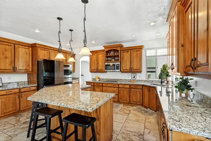Kitchen featuring wood cabinetry, granite countertops, and stainless steel appliances