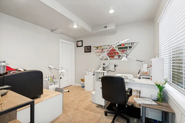 Recessed lighting, wall-mounted shelving, window with horizontal blinds, and a white interior door