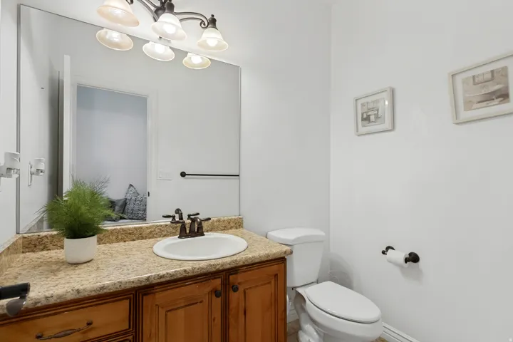 Vanity with a solid surface countertop, an undermount sink, and a bronze-finish faucet