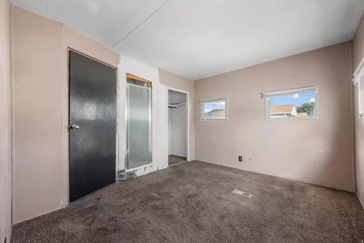 Wall-to-wall carpeting with light-toned walls and multiple windows