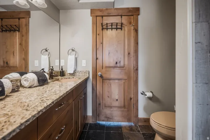 Wood-finish vanity with a stone-finish countertop and integrated sink