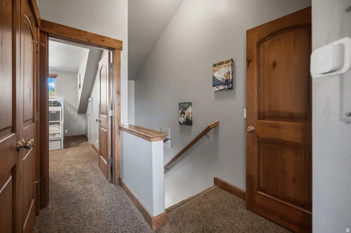 Wood-paneled doors with rounded top panels, wood trim detailing, and carpeted flooring