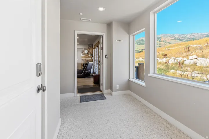 Entry foyer with neutral wall paint and light-toned carpeting