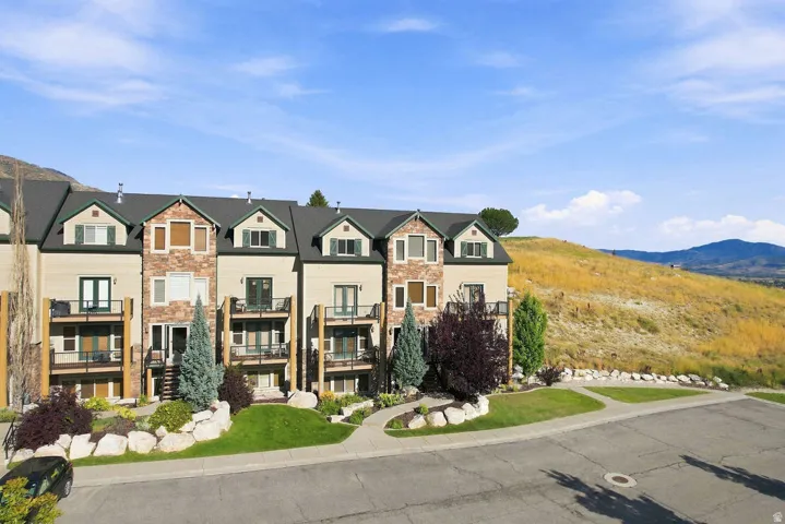Multi-level townhome exteriors featuring dormer windows, stone accent siding, and private balconies