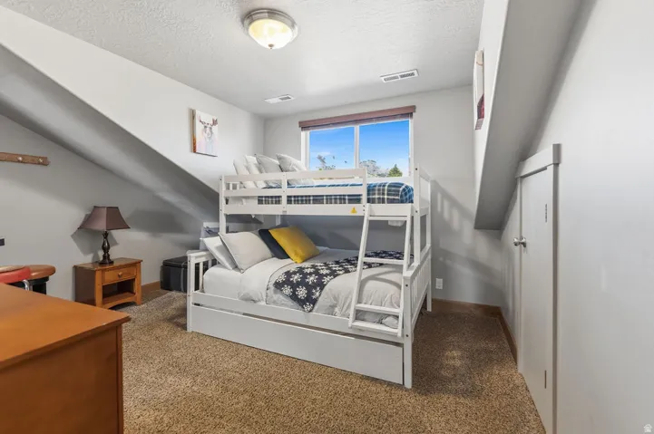 Carpeted flooring, recessed window, ceiling-mounted light fixture, and built-in storage door