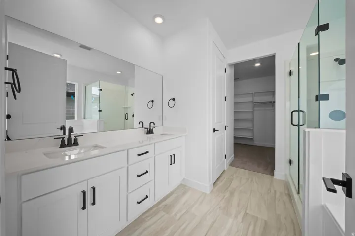 Dual vanity with integrated sinks, white cabinetry, and matte black fixtures
