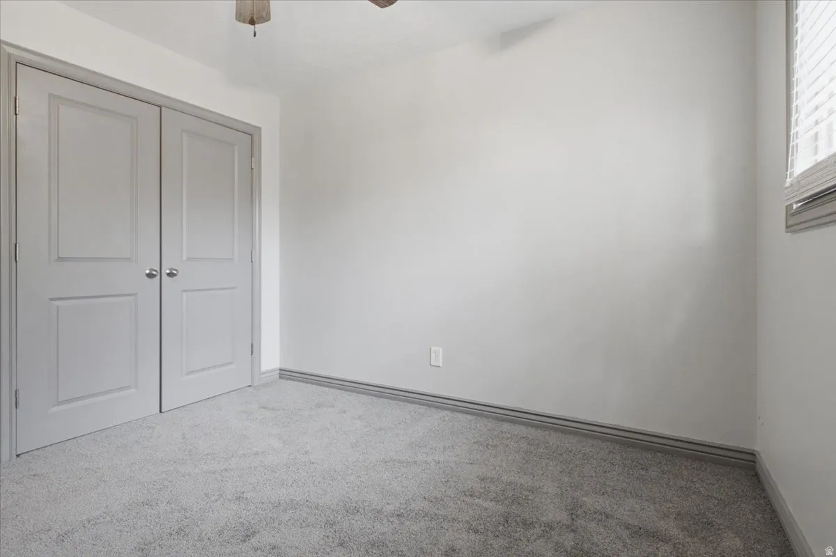 Neutral-toned carpeting, light gray walls, and double panel doors with silver-tone hardware