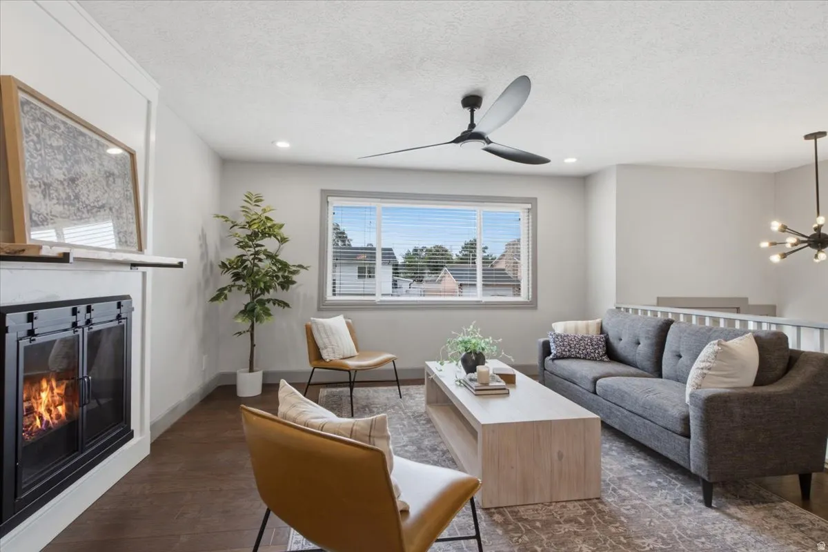 Hardwood-style flooring, white walls, recessed lighting, and a modern fireplace with a white mantel and black firebox