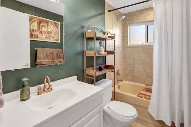 White vanity with integrated sink, bronze-finish faucet, and coordinating mirror