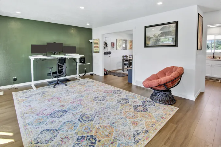 Wood-finish flooring throughout, recessed lighting, and a distinct accent wall