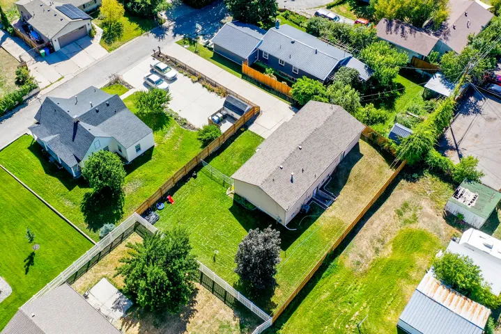 Expansive lot featuring a residential structure with a light-colored roof