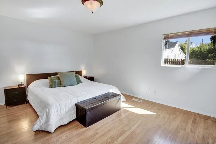 Light wood-finish flooring, white walls, and a ceiling-mounted light fixture