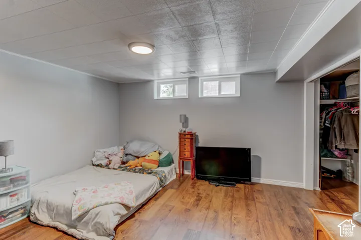 Hardwood-finish flooring, two upper windows, flush mount ceiling light, and built-in closet with shelving