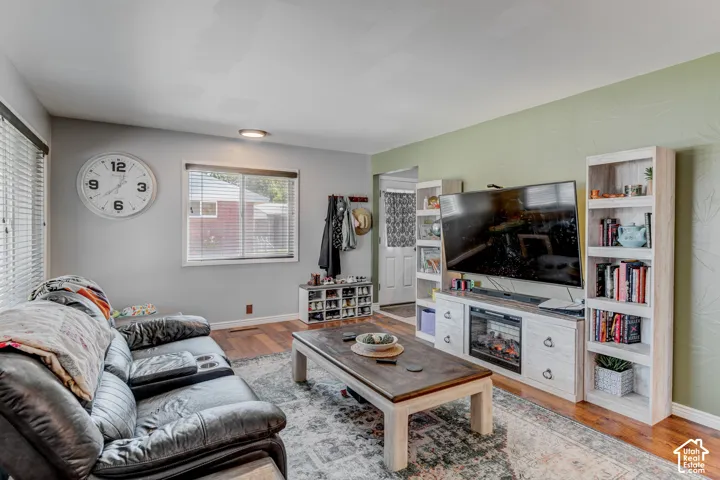 Hardwood-finish flooring, built-in shelving, two windows with blinds, and recessed lighting