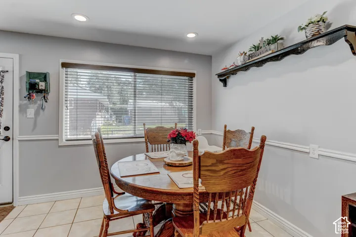 Recessed ceiling lighting, tiled flooring, built-in decorative wall shelf, window with wood-finish trim, and white chair rail molding