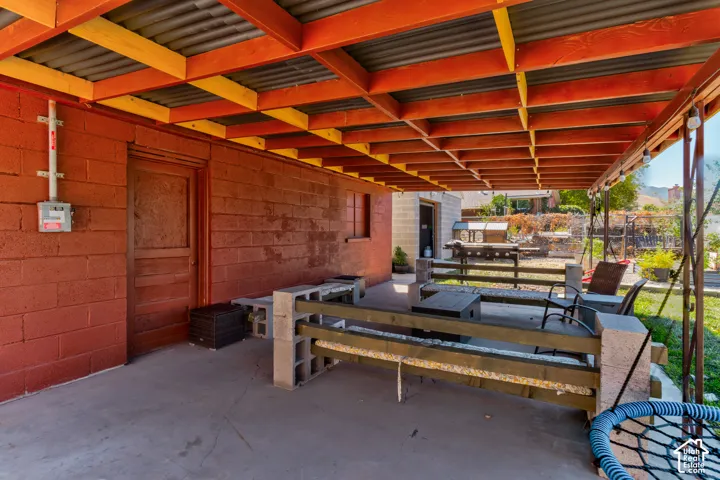 Covered outdoor patio with a corrugated metal roof and exposed wood beams