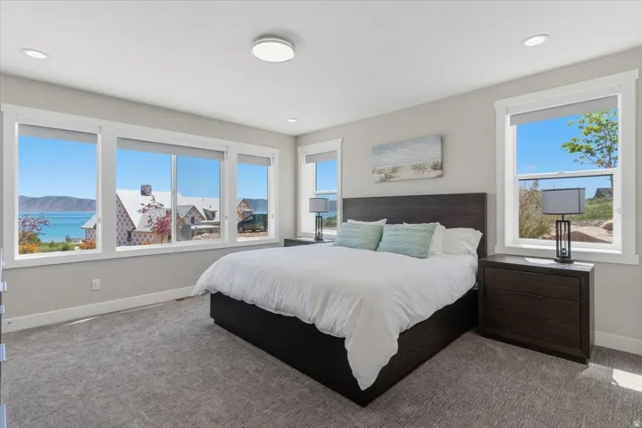 Multiple large windows, recessed ceiling lighting, and light gray wall paint