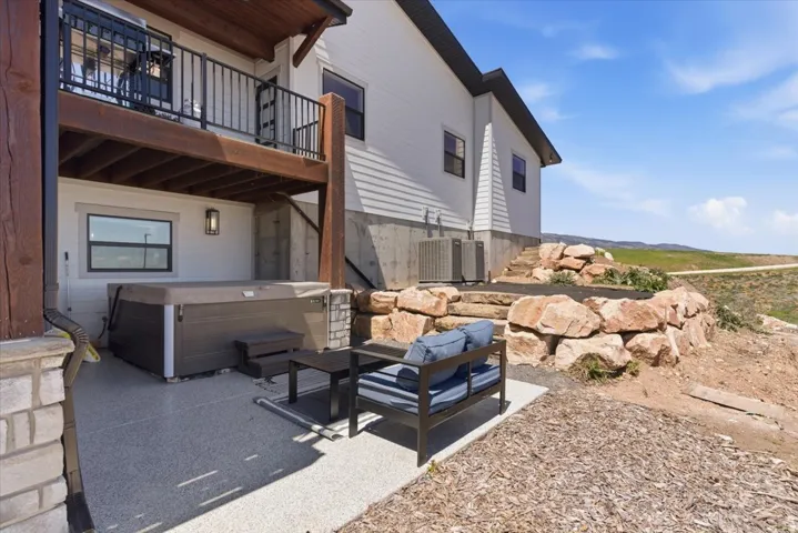 Lower-level patio with a hot tub and adjacent outdoor seating area