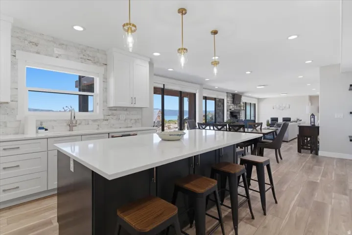 Gourmet kitchen with a large central island, white cabinetry, integrated sink, and white countertops