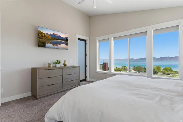 Spacious room with a vaulted ceiling, extensive window array, and durable carpet flooring