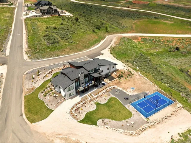 Contemporary residence featuring a multi-level design, a dark shingle roof, and a stone chimney