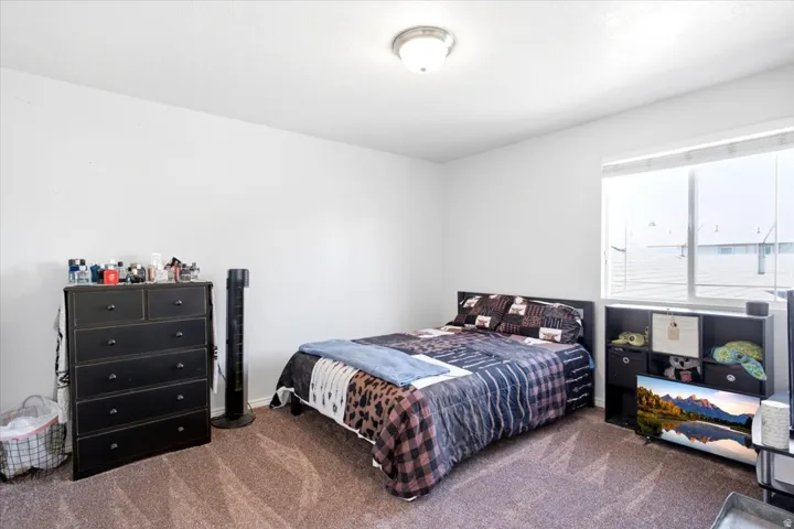 Neutral wall finishes, recessed ceiling light fixture, large window with blinds, and carpeted flooring