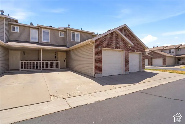 Brick and siding exterior with two garage doors and an attached covered porch