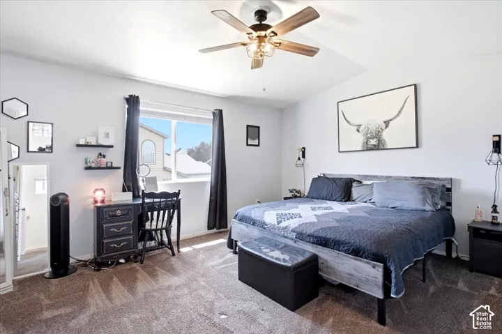 Vaulted ceiling with a ceiling fan, carpeted flooring, a window with a sill, and built-in wall shelving