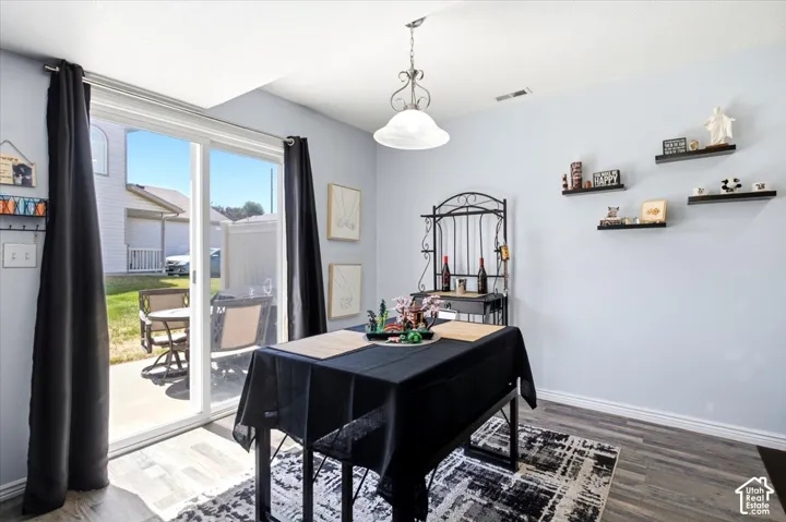 Sliding glass patio door, wood-finish flooring, ceiling-mounted light fixture, wall-mounted shelving, and light blue wall finish
