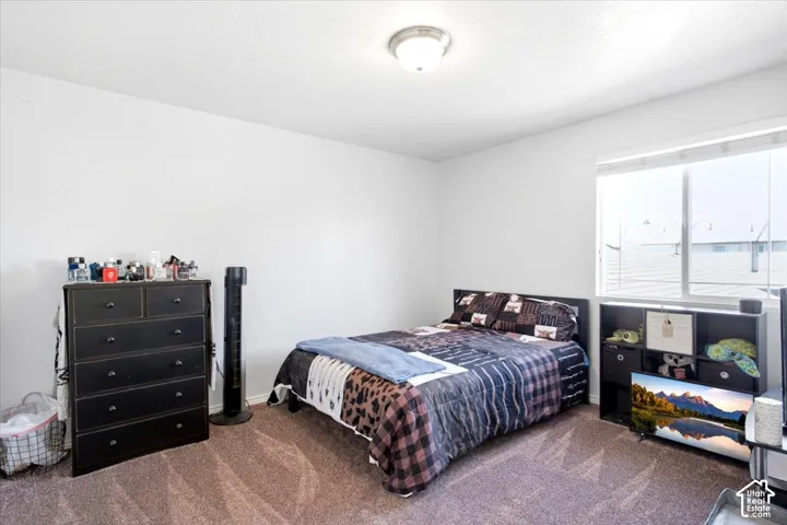 Neutral wall finishes, recessed ceiling light fixture, large window with blinds, and carpeted flooring