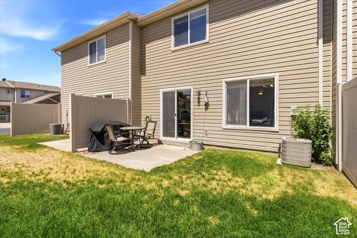Private patio area with concrete hardscaping, partial privacy fencing, and direct access to interior via sliding glass door