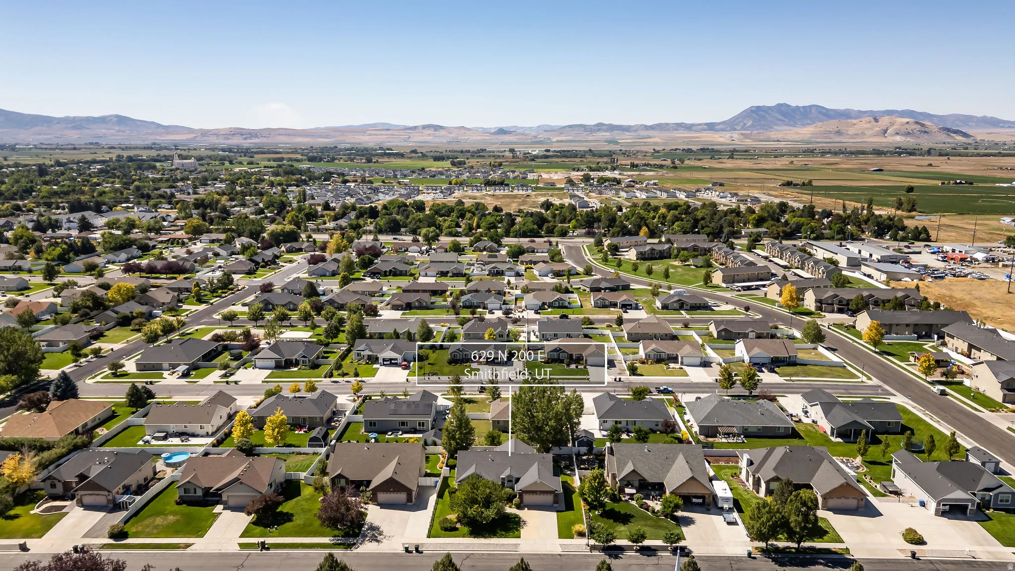Residential neighborhood with established homes, paved streets, and a mountainous backdrop
