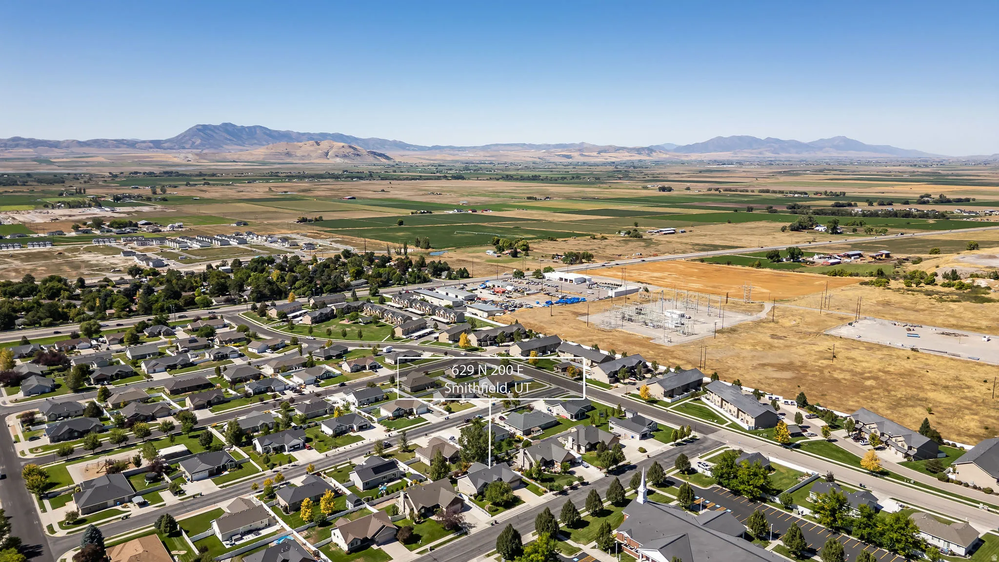 Residential neighborhood with established homes, paved streets, and a mountainous backdrop