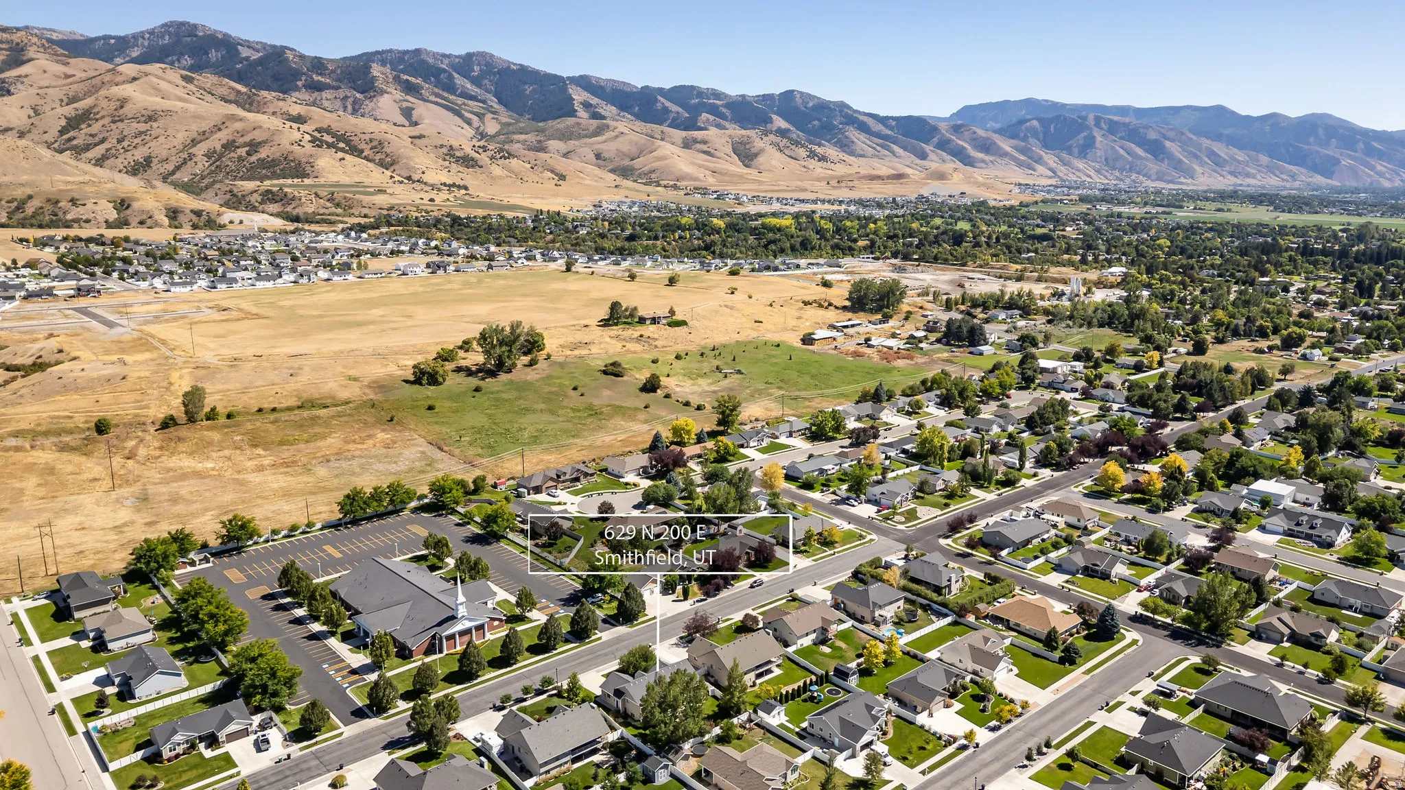 Residential neighborhood with established homes, paved streets, and a mountainous backdrop