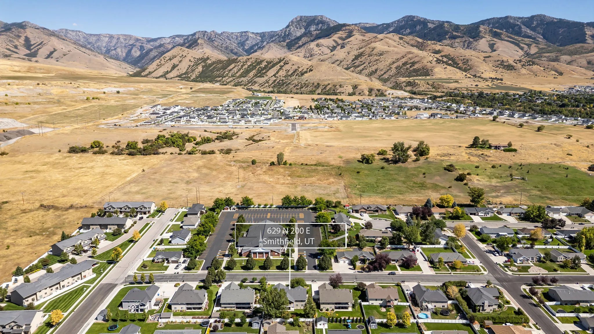 Residential neighborhood with established homes, paved streets, and a mountainous backdrop