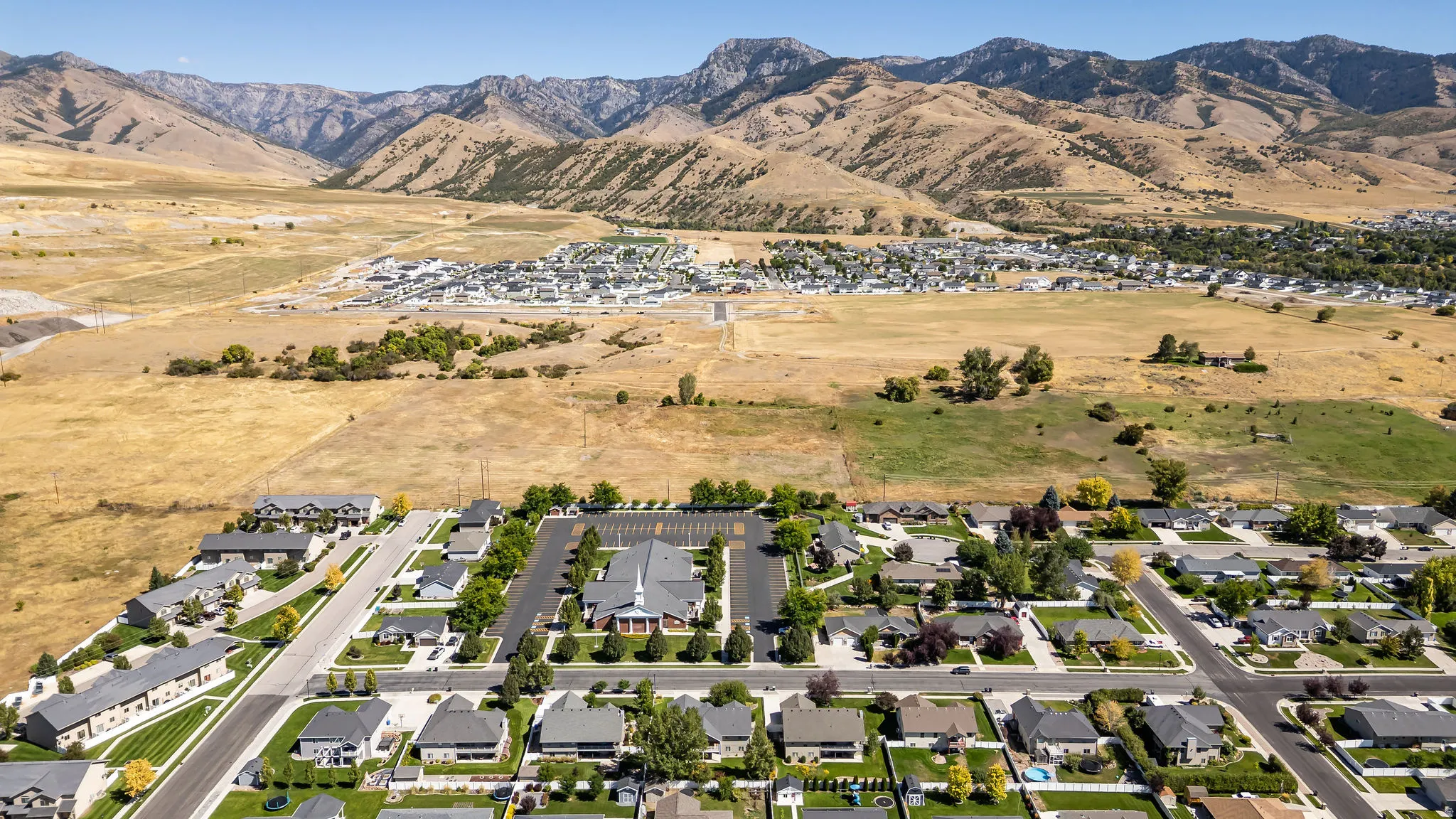 Residential neighborhood with established homes, paved streets, and a mountainous backdrop