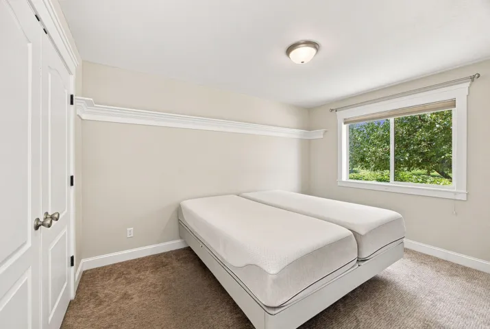 Bedroom 1. Neutral wall tones, crown molding, white trim, recessed closet doors, and a flush mount ceiling light