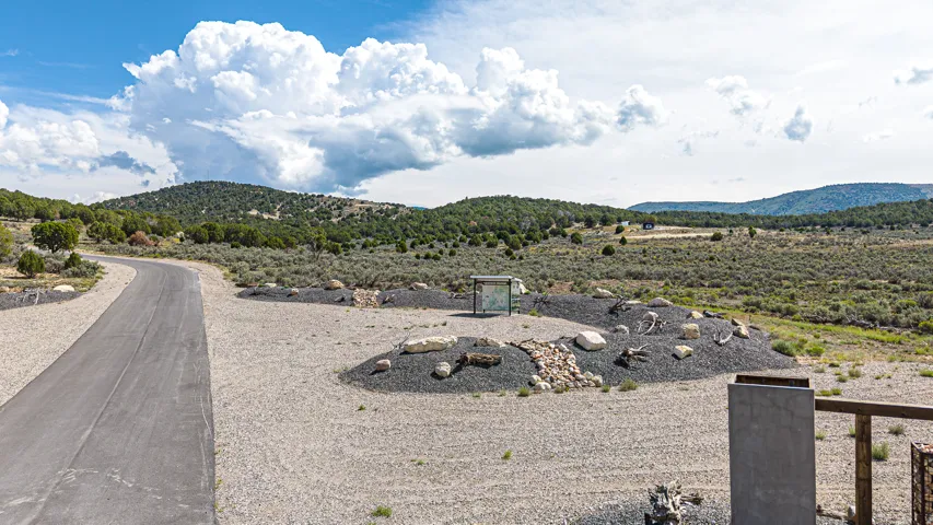 Paved drive leading to natural landscape with extensive open terrain