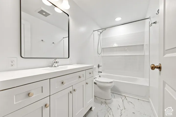Basement full bathroom: White vanity with extensive storage, countertop, and an undermount sink