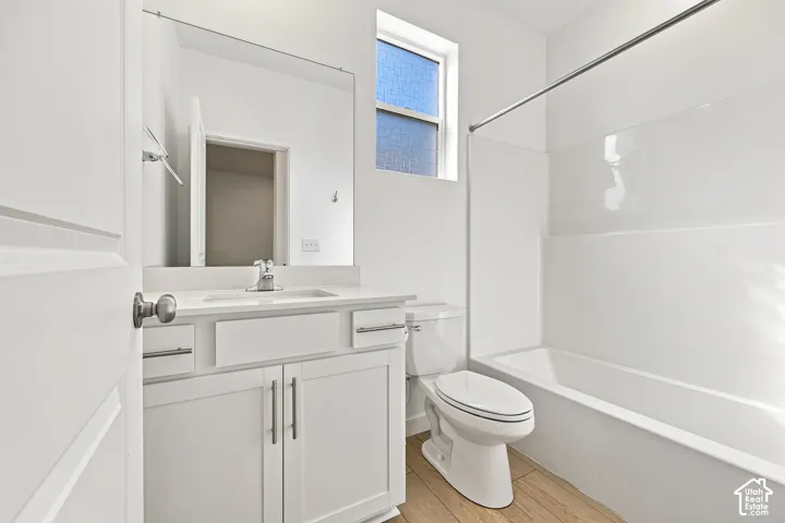 Full main level bathroom: White vanity with brushed nickel hardware, a single basin sink, and a large mirror