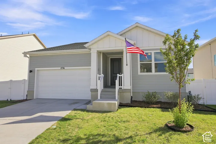 Siding exterior with a covered entry, attached garage, and a concrete driveway