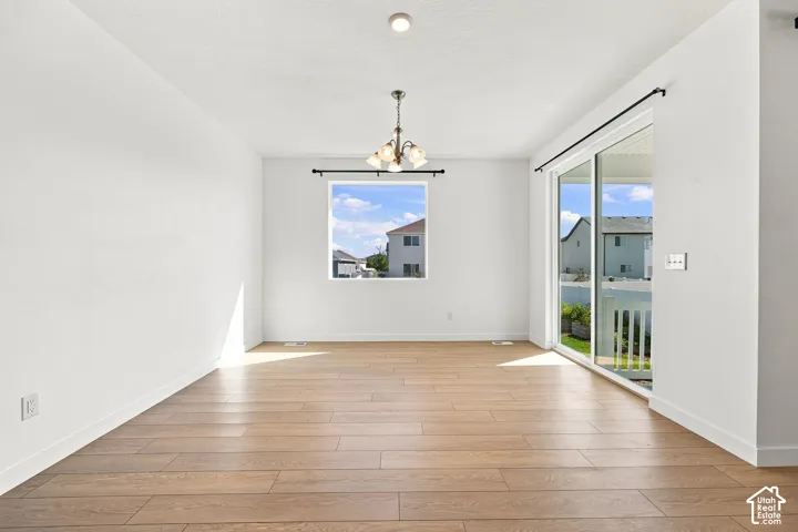 Recessed ceiling lighting, wood-finish flooring, and a contemporary chandelier