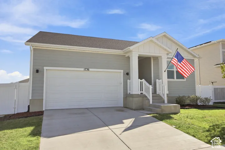 Contemporary exterior featuring light grey siding, white trim, an attached garage, and a covered porch with white railings