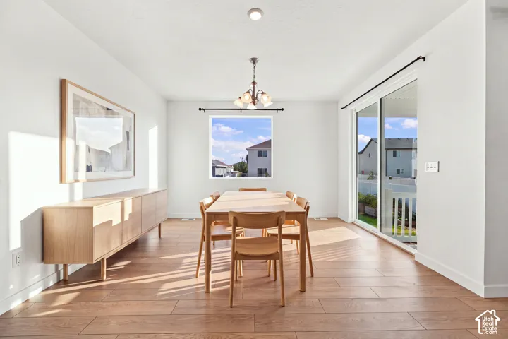 Recessed ceiling lighting, wood-finish flooring, sliding glass door with balcony access, and a window for natural illumination
