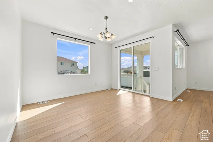 Wood-finish flooring, recessed lighting, and a modern chandelier