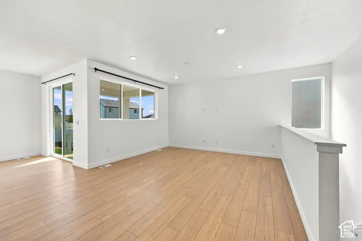 Wood-finish flooring, recessed lighting, and white painted walls