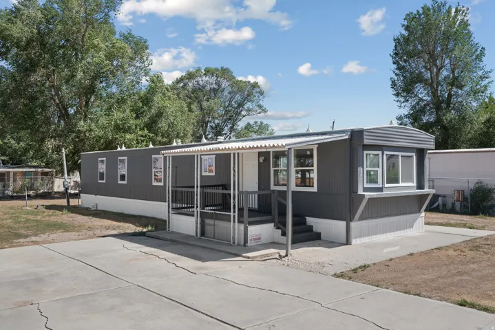 Siding exterior with multiple windows, covered porch, and concrete driveway