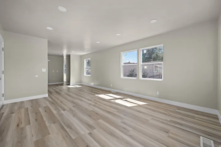 Expansive room featuring wood-finish flooring, recessed ceiling lighting, and multiple windows