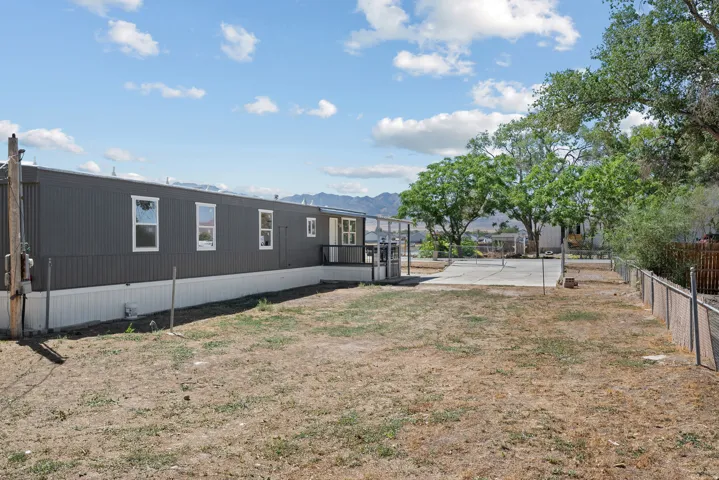 Dark gray exterior siding with white trim windows and a white foundation skirt