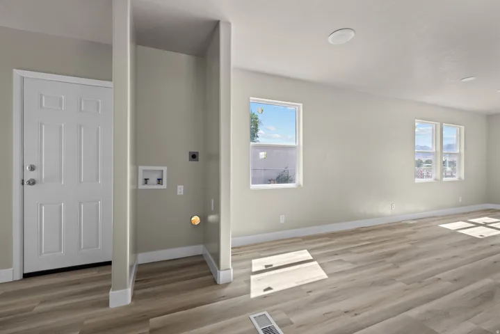 Wood-finish flooring, multiple windows, recessed lighting, and a dedicated laundry area